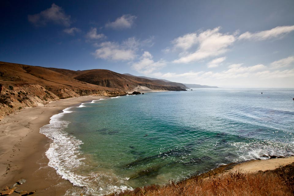 crescent shaped beach with low hills