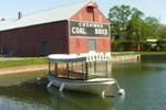 Canal cuts in front of Cushwa Visitor Center with a canal boat floating in the water.