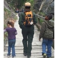 Park ranger walking with two youth.