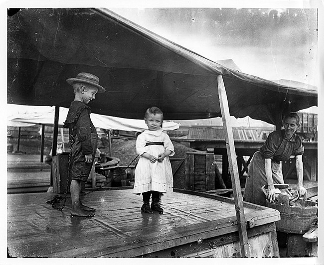 Two small children tied to the cabin of a canal boat as a precaution.