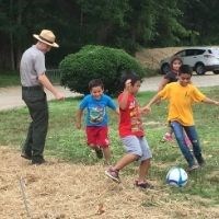Youth and Park Ranger playing soccer.