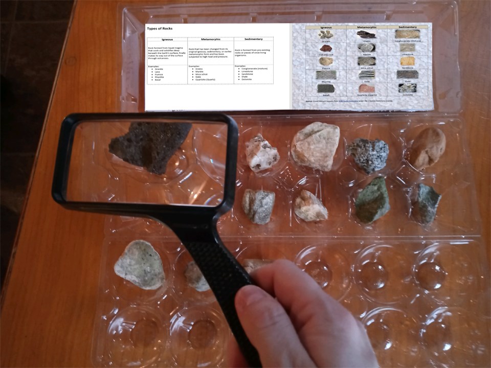 Examining the rocks by looking through a magnifying glass and sorting the rocks.