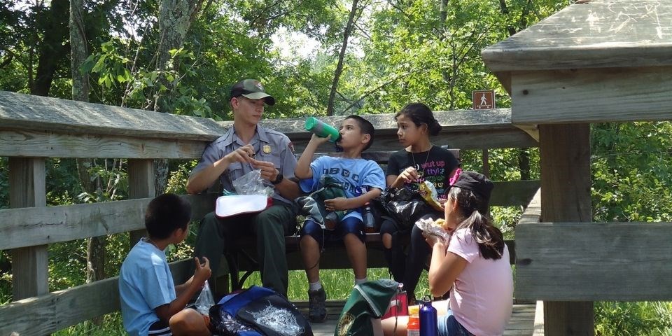 Park ranger and youth group enjoying lunch in the park.