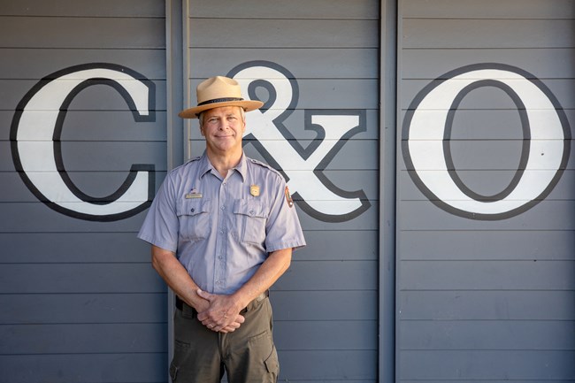 Photo of Superintendent Wenschhof in front of a gray building that says "C&O"