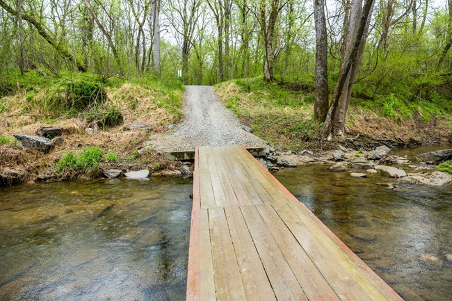 A low wooden bridge crosses the Little Catoctin Creek