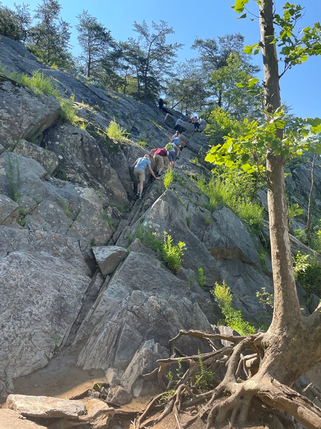Hikers climbing traverse wall