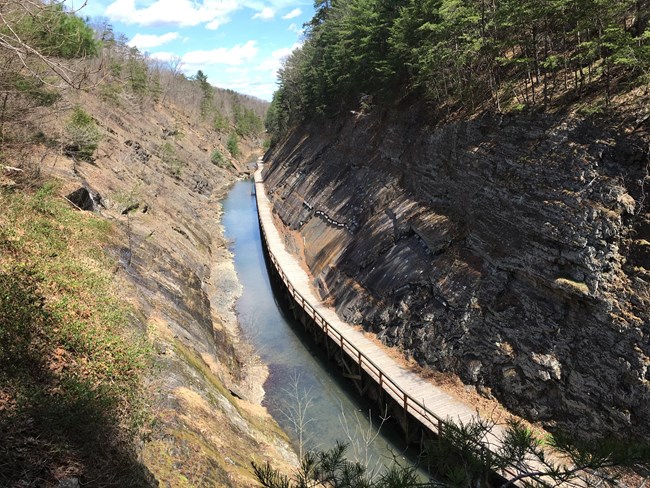 A birds-eye view of a boardwalk pathway coming from the Paw Paw Tunnel.