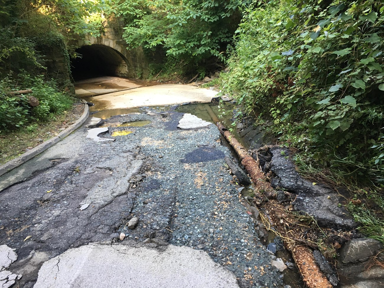 An asphalt roadway with severe erosion and surface damages