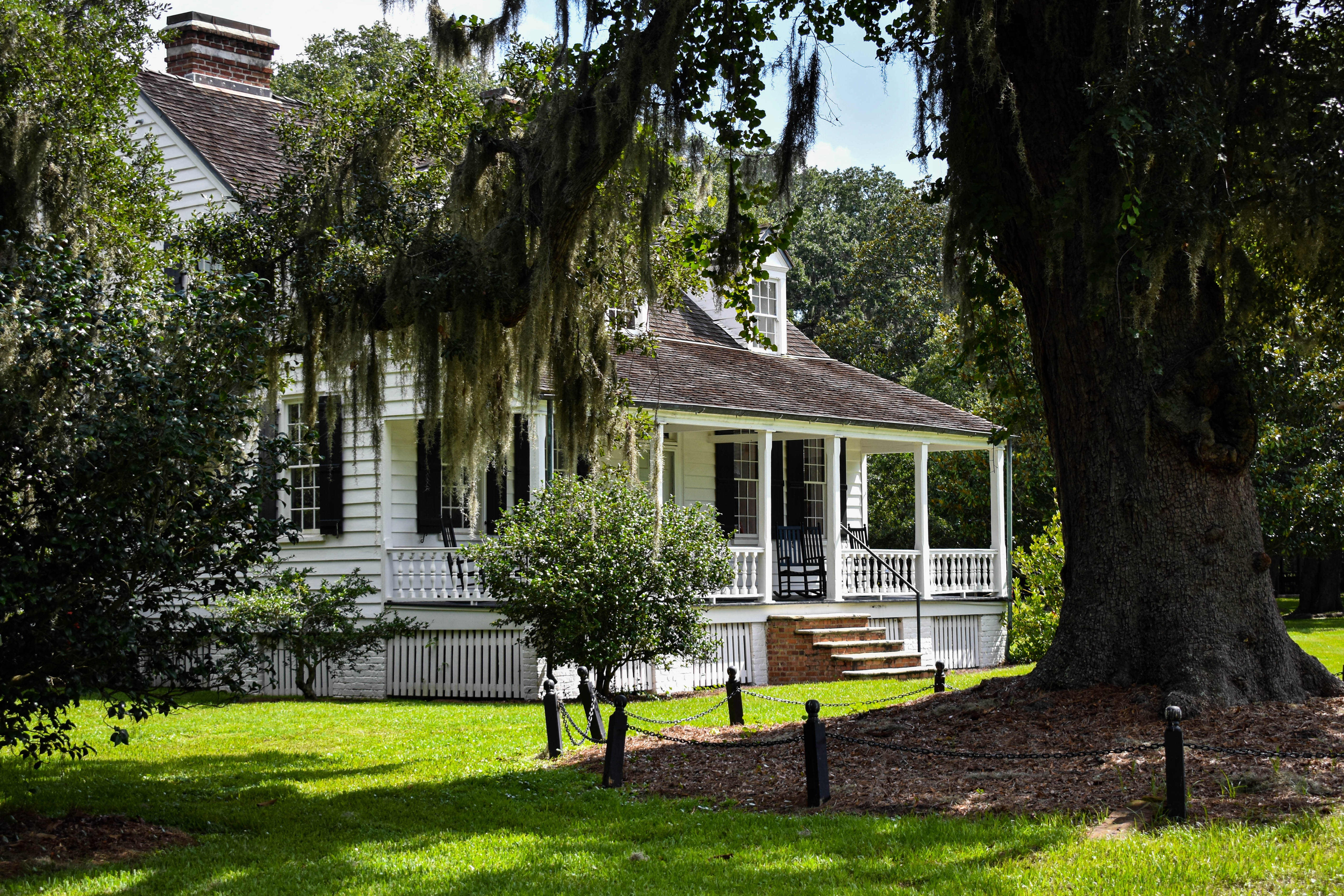 The White Plantation Cottage A white, wooden plantation style home.