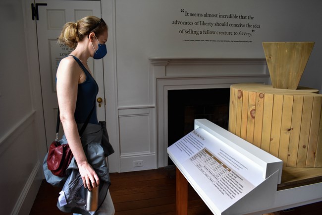 A blonde female visitor views the exhibits inside the historic home