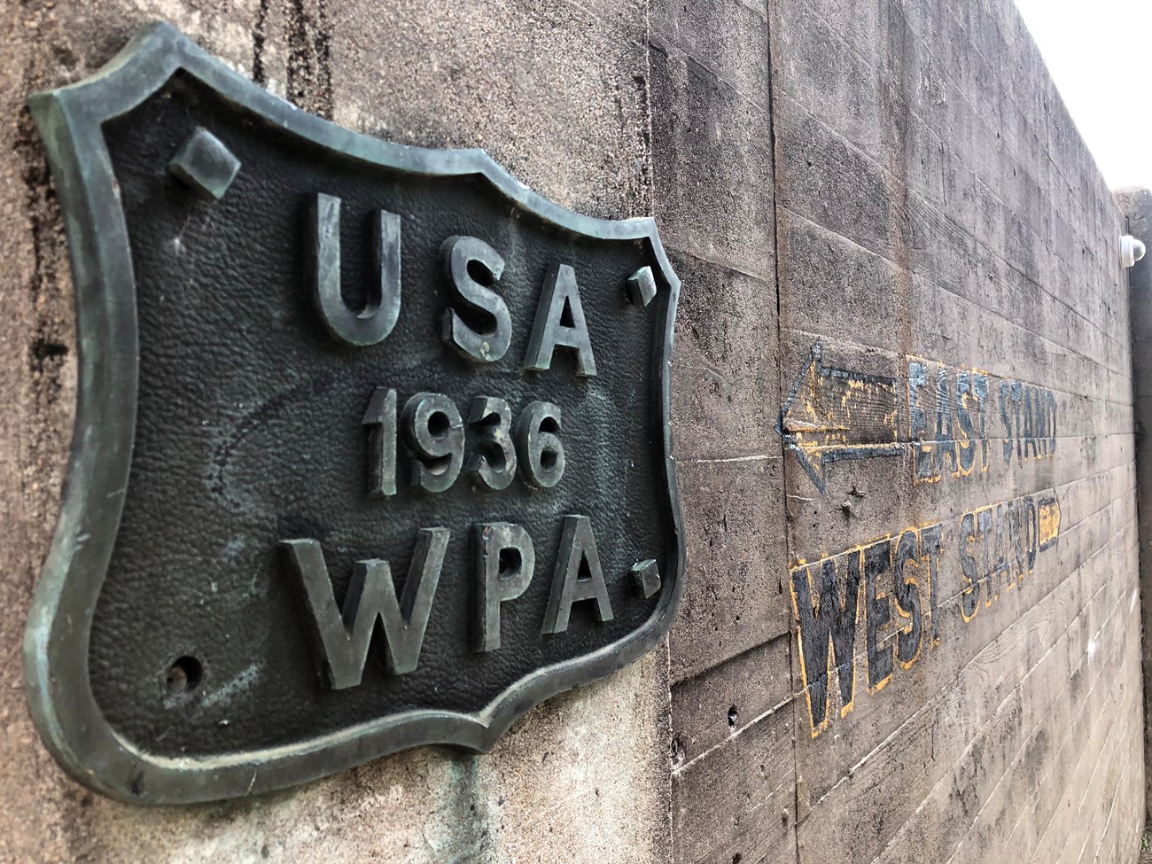 A shield-shaped Works Progress Administration plaque from 1936 adorns the concrete walls around Quigley Stadium, the school's current football facility.
