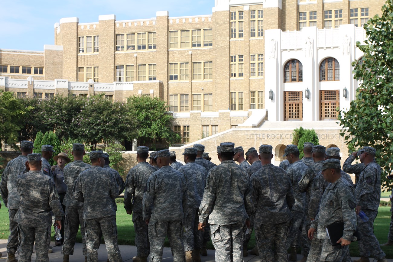 A group of Arkansas National Guard soldiers on a fieldtrip participate in a ranger-led program in front of Little Rock Central High School.