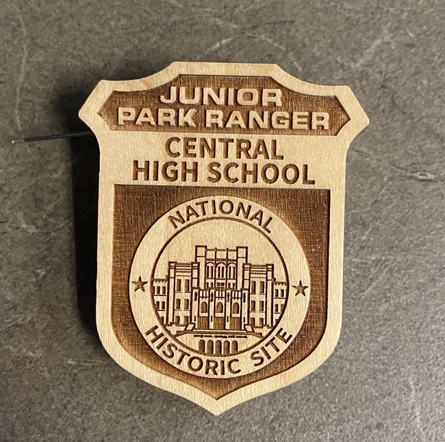 The junior ranger badge features the words "Junior Park Ranger," "Central High School," and "National Historic Site" with an engraved image of the school's facade in a center round frame.
