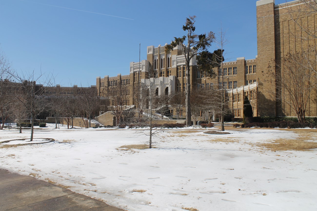 Snow covers the grounds of Little Rock Central High School on a winter day.