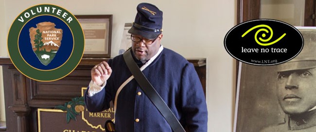 A ranger in period uniform speaks to visitors, the NPS Volunteer logo to the left and the Leave No Trace logo to the right, above a portrait of Charles Young.