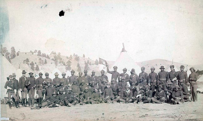 African American Soldiers in two rows in front of tents