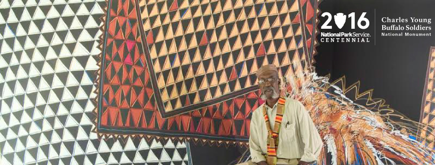 Large artwork on display with a man in the foreground