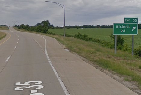 A gray paved road and exit ramp going off to the right with sign text reading Bickett Road