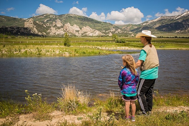 Mother and daughter fishing with rocks in background