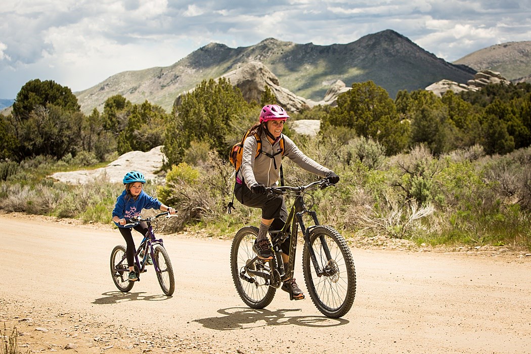 Mother and daughter mountain bike on a road in City of Rocks.