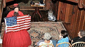 Actress Mary Ann Jung dressed as Clara Barton holds an American Flag during a performance of Clara Barton Red Cross Angel.