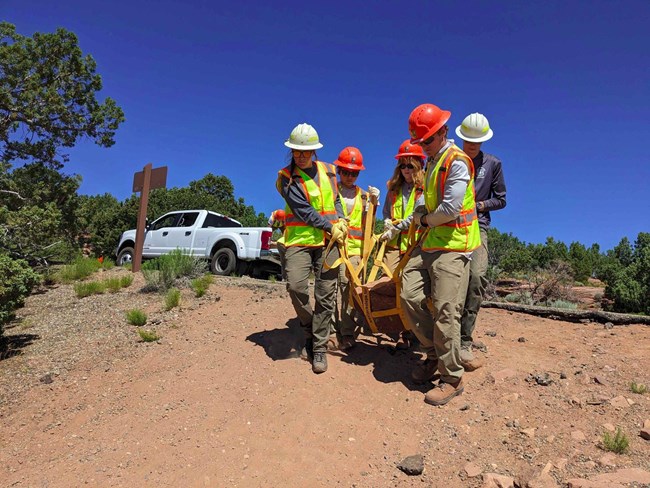 Teens working as a team to move a large rock