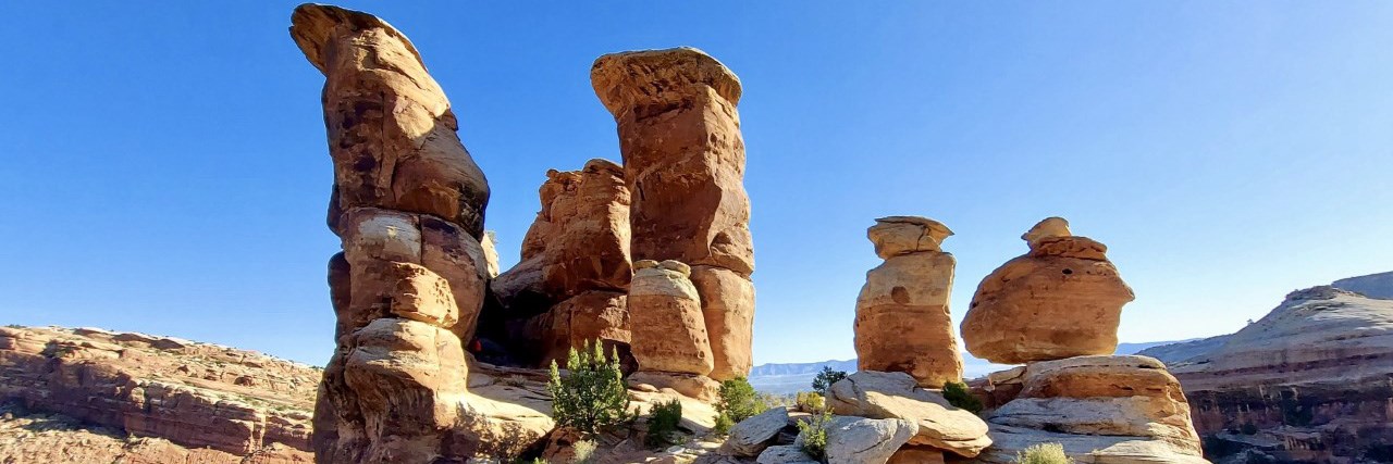 Five varying sizes of towers of red orange sandstone at Devils Kitchen