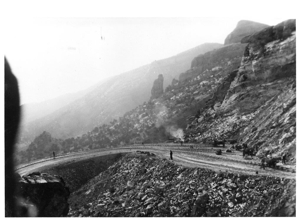 Black and white photograph of men working on a curved portion of Rim Rock Drive