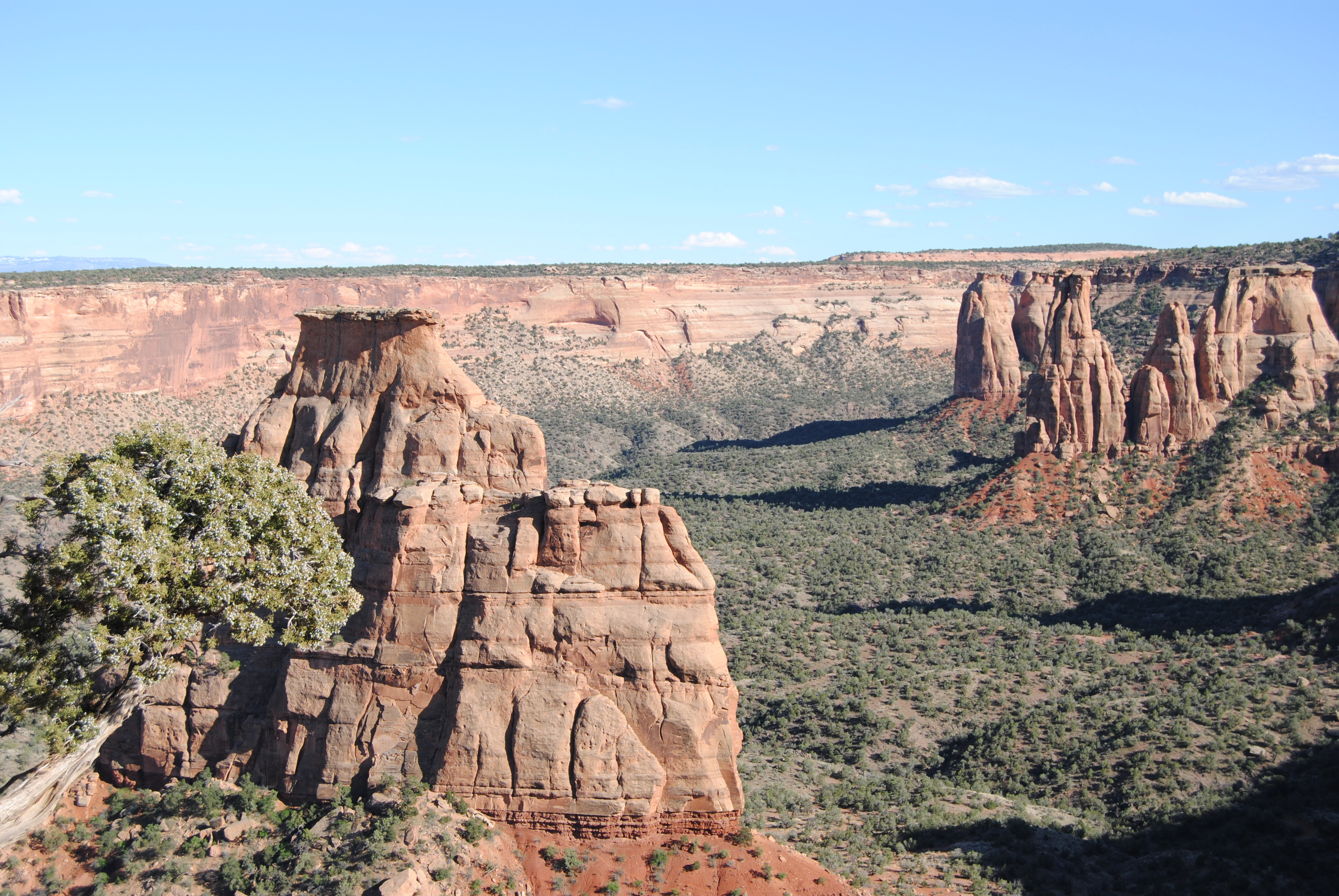 Independence Monument and Monument Canyon from Ottos Trail - NPS photo Large rock monolith within a wide canyon. In the background along the canyon wall are other rock monoliths.