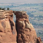 Adjacent, touching towers of red-orange sandstone, an oblong space near the top between the two towers