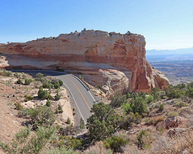 A road going through sandstone canyons and a view across a valley