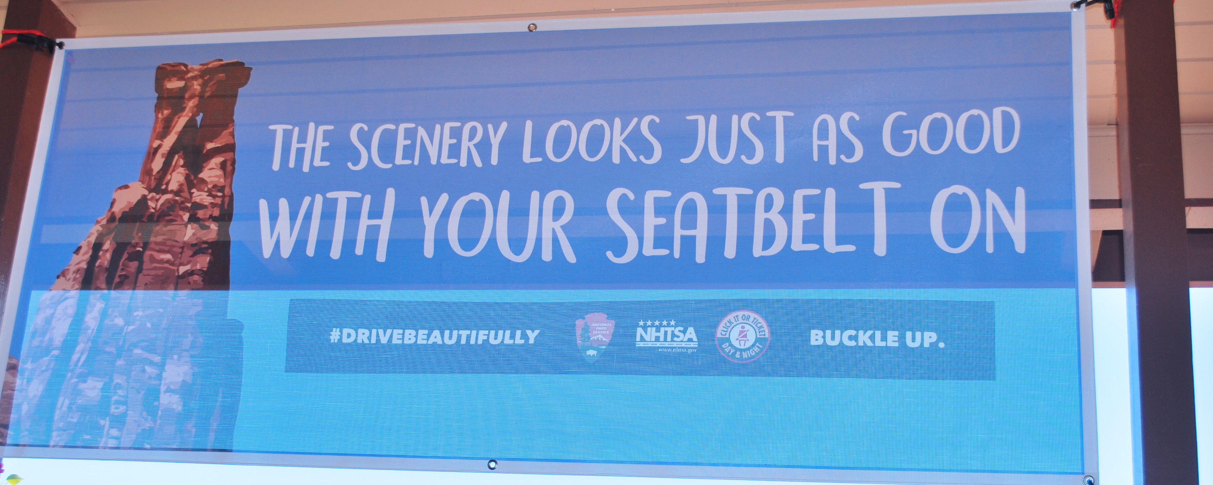 translucent banner with text "The scenery looks just as good with your seatbelt on."