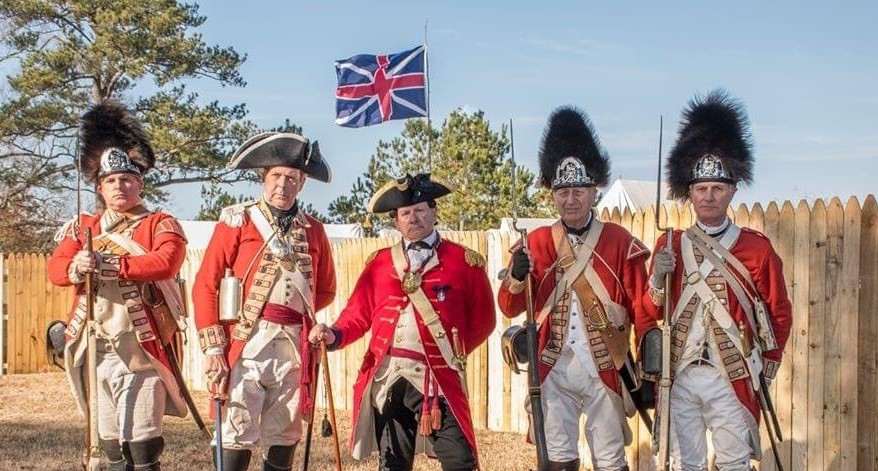 British British soldiers. 5 British soldiers in 18th century uniforms (red coats) stand before a British FLag