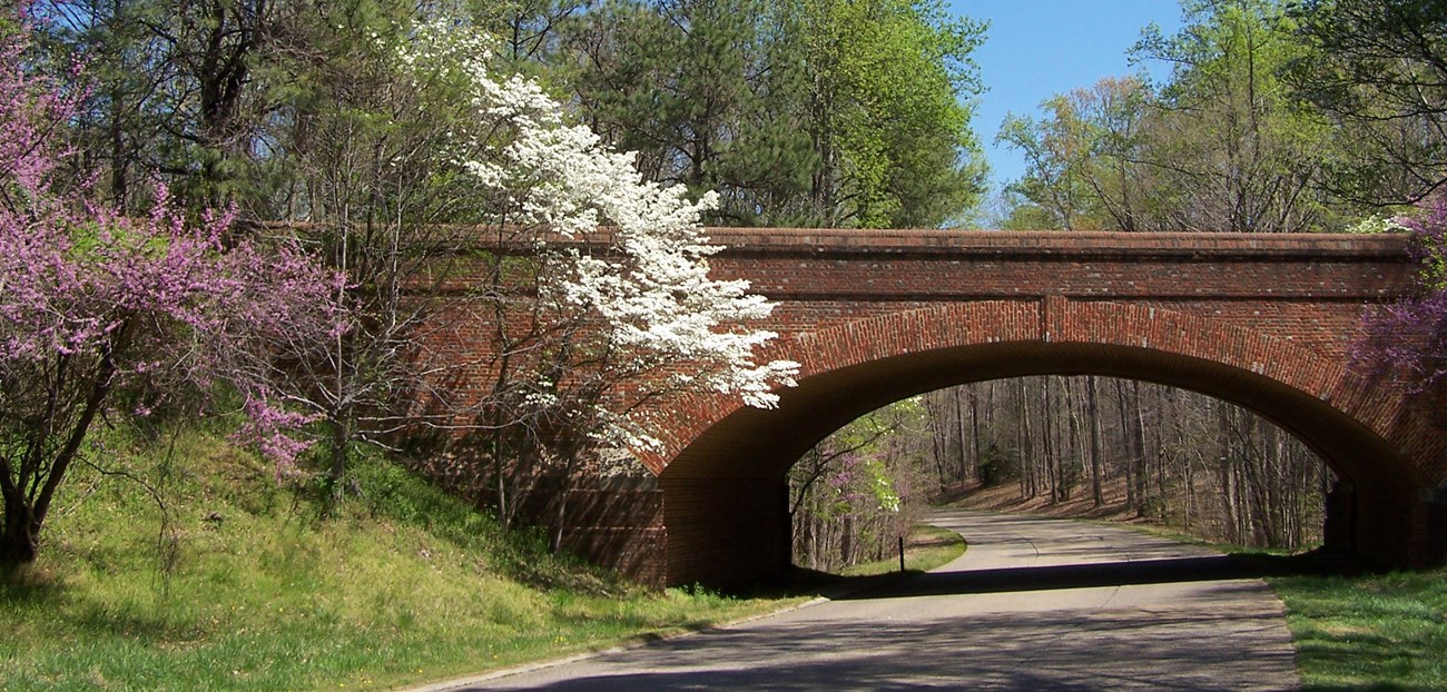 A brick bridge crosses a road