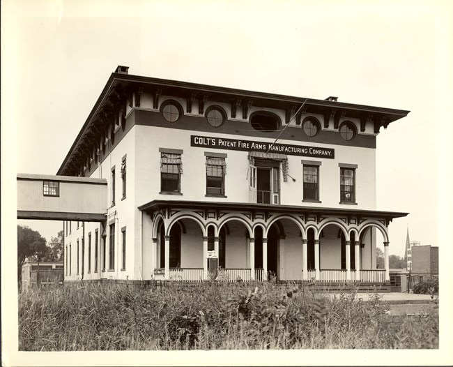 A black and white photo of the Colt Office Building in 1940. With multiple windows and an porch.