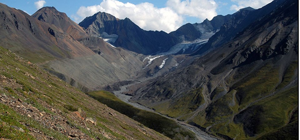 a glacier sits high in a valley