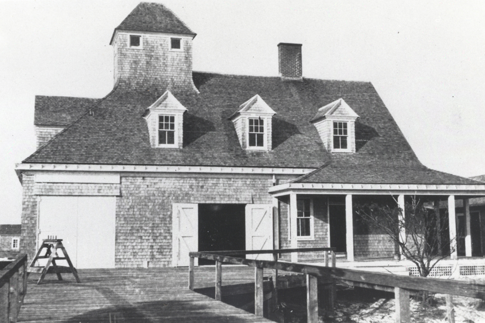 Black and white photo of a two story wooden building.