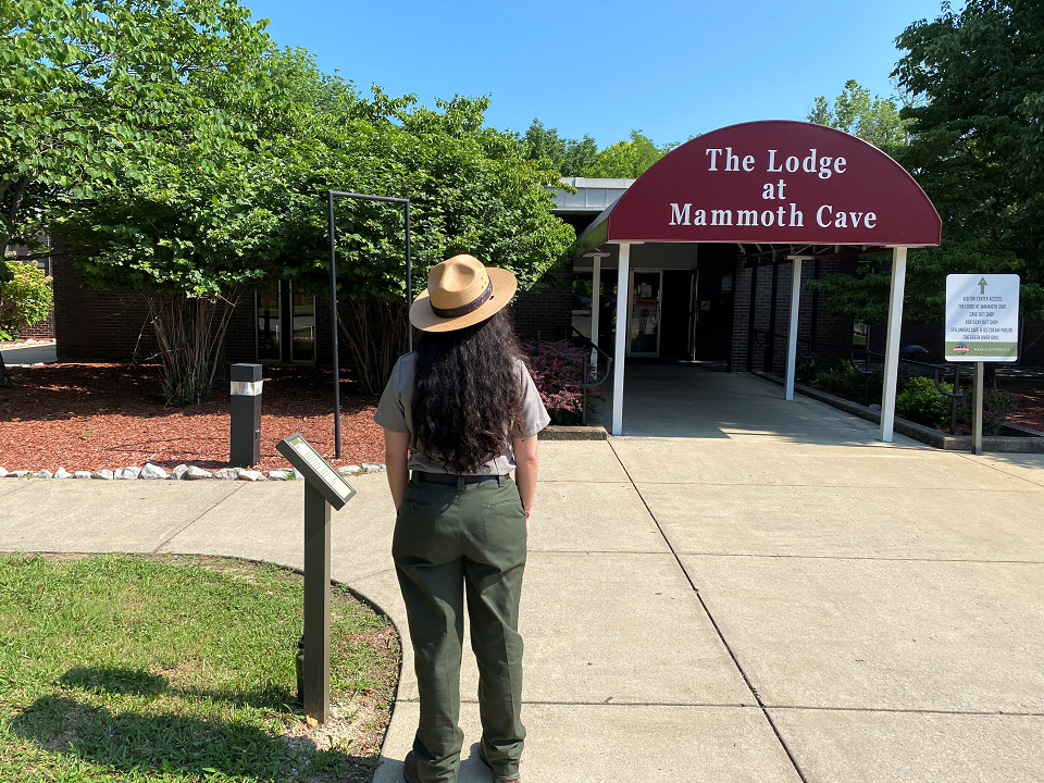 A park ranger standing in front of the main lodge building