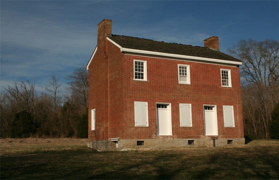 A two story brick building with white trim and two doors.