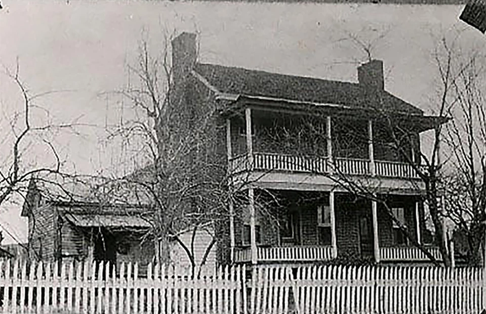 A two story brick building with white trim and two doors.