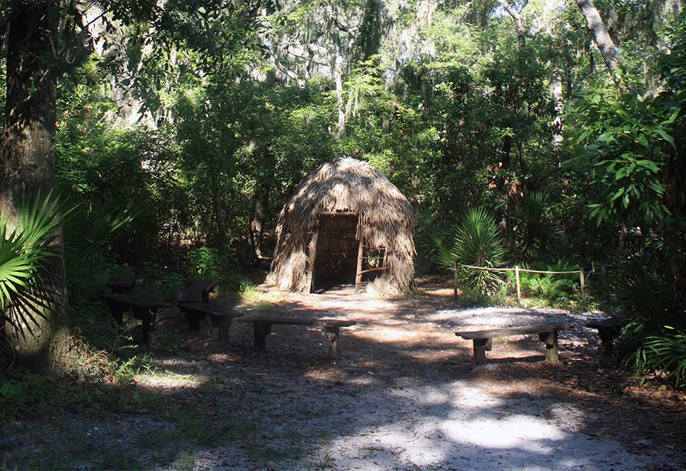 a small thatch hut and a pile of oyster shells