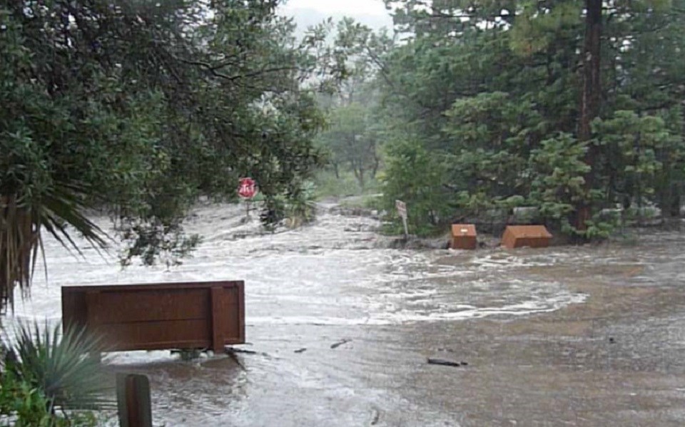 Flooded parking lot with brown flowing water.