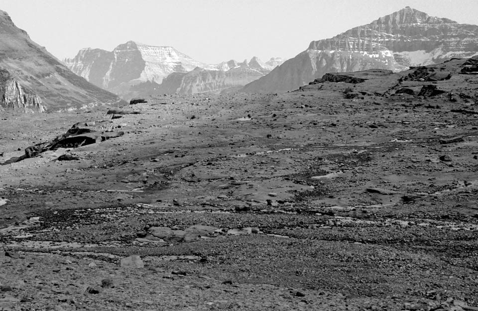 A glacier with people standing on and around it.