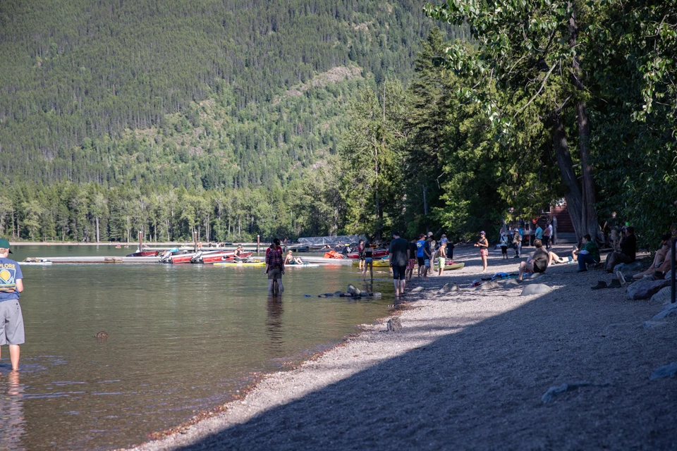 People stand on a beach in sunny weather.