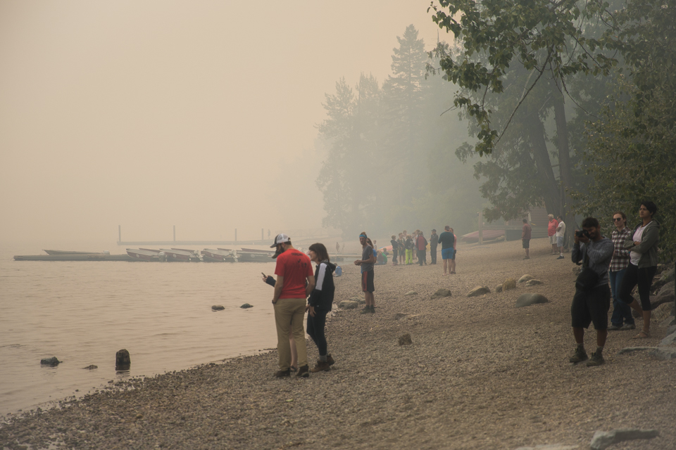 People stand on a beach in sunny weather.