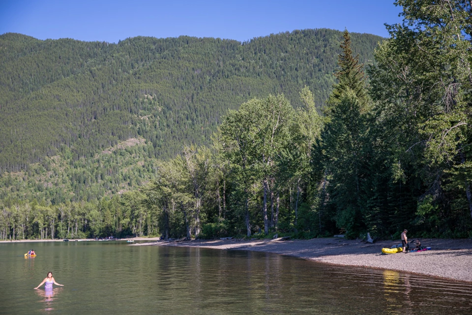People stand on a beach in sunny weather.