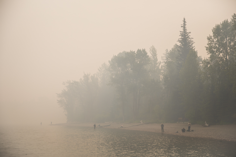 People stand on a beach in sunny weather.