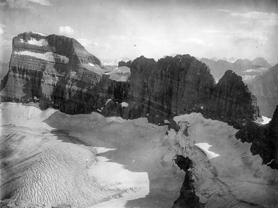 A mountainous glacier below a rocky mountain.