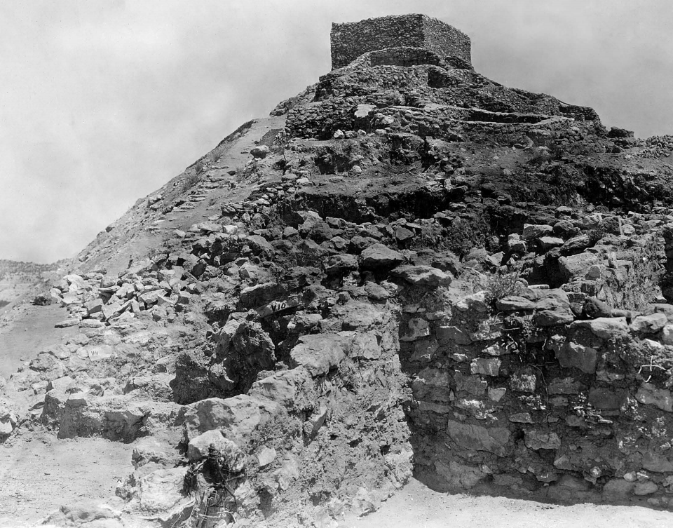 A steep hillside covered in large rocks from collapsed pueblo walls