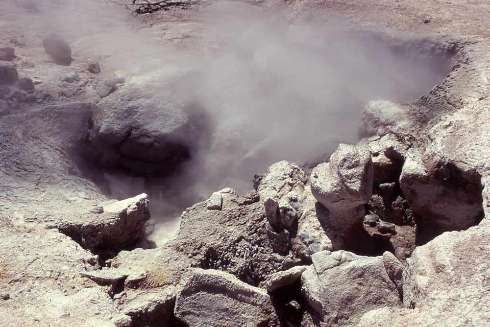Steam rises from a cracked and contorted hole in the ground.